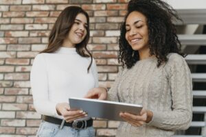 Mulher usando um laptop em um ambiente de trabalho moderno, representando o empoderamento feminino na tecnologia.