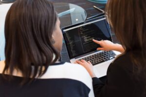 A presença e o papel das mulheres na tecnologia têm sido cada vez mais reconhecidos e valorizados e essa imagem de duas mulheres trabalhando com um notebook retrata um pouco disso.
